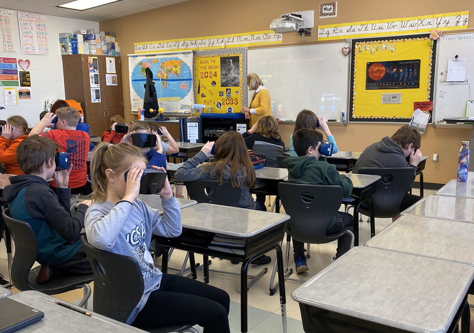Image of Teacher Showing Students How to Use VR Headsets