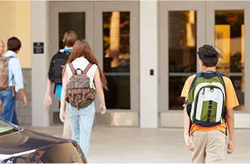 Image of Students Walking into School with Backpacks Image of Students Walking into School with Backpacks