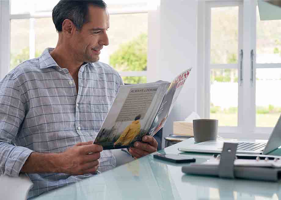 Image of Man Reading Magazine at Breakfast