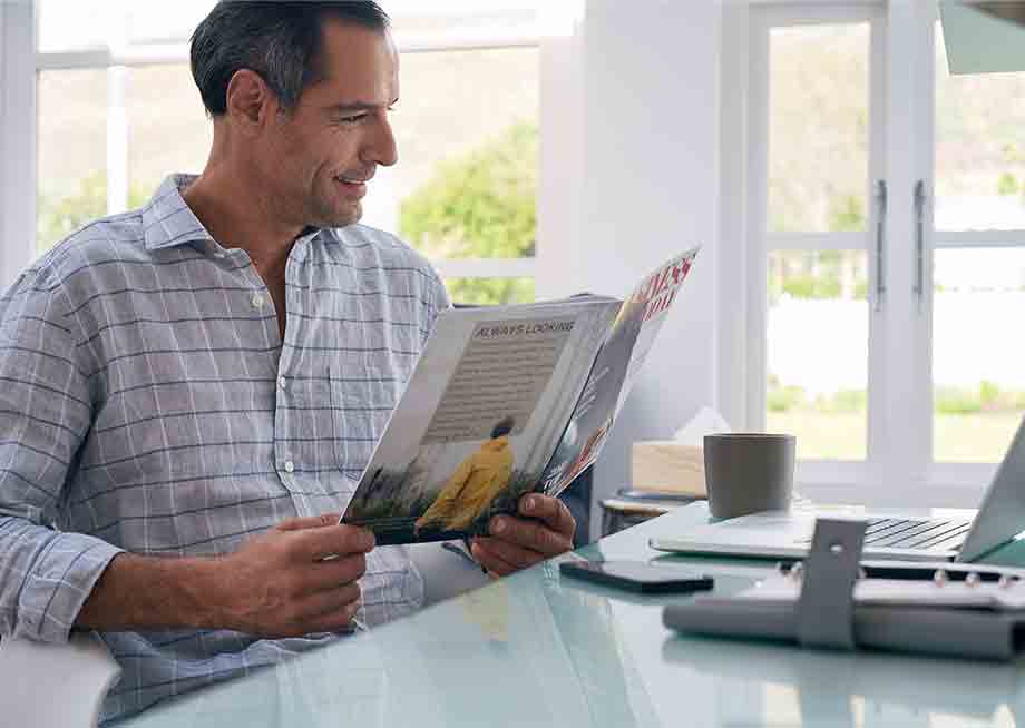 Image of Man Reading Magazine at Breakfast Image of Man Reading Magazine at Breakfast