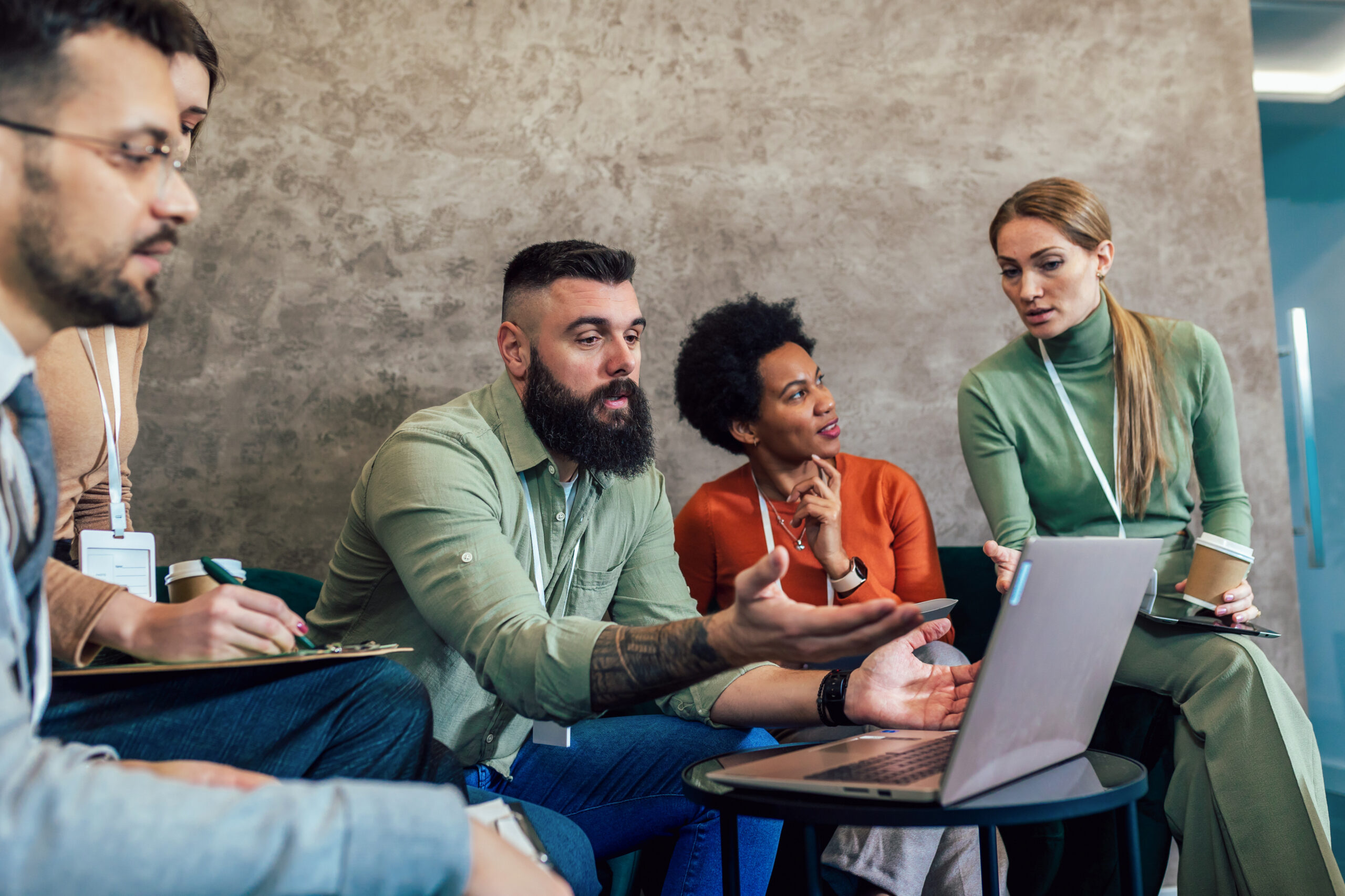 Businesspeople working in an office lobby. Group of  businesspeople sitting together in a co-working space